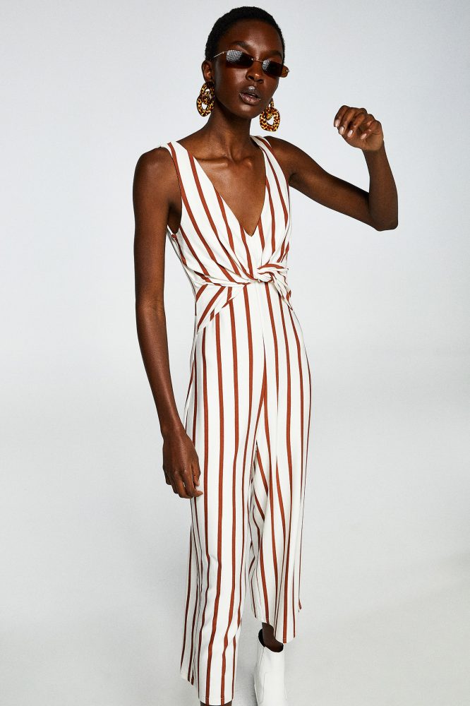 Sfera 29,99€ - Mono de rayas en blanco y camel. Escote en V y detalle de nudo en el pecho.